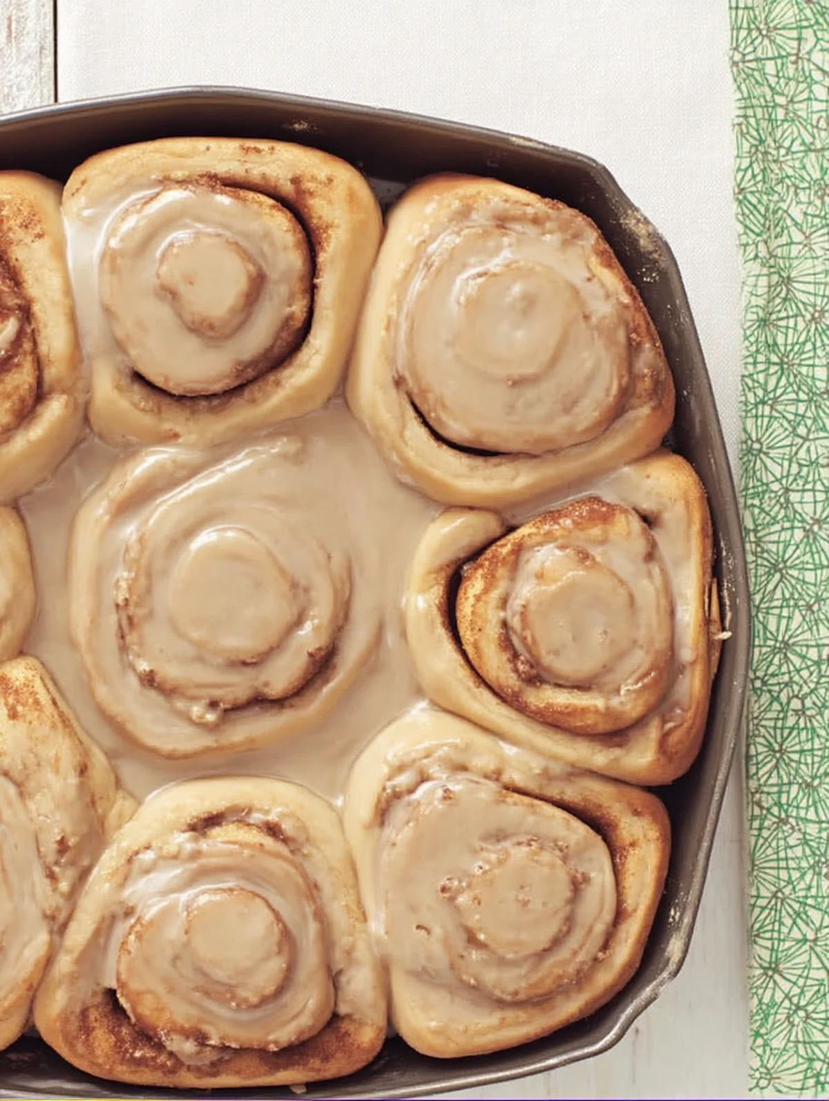 Cinnamon roll recipe dough being rolled out with butter and sugar filling
