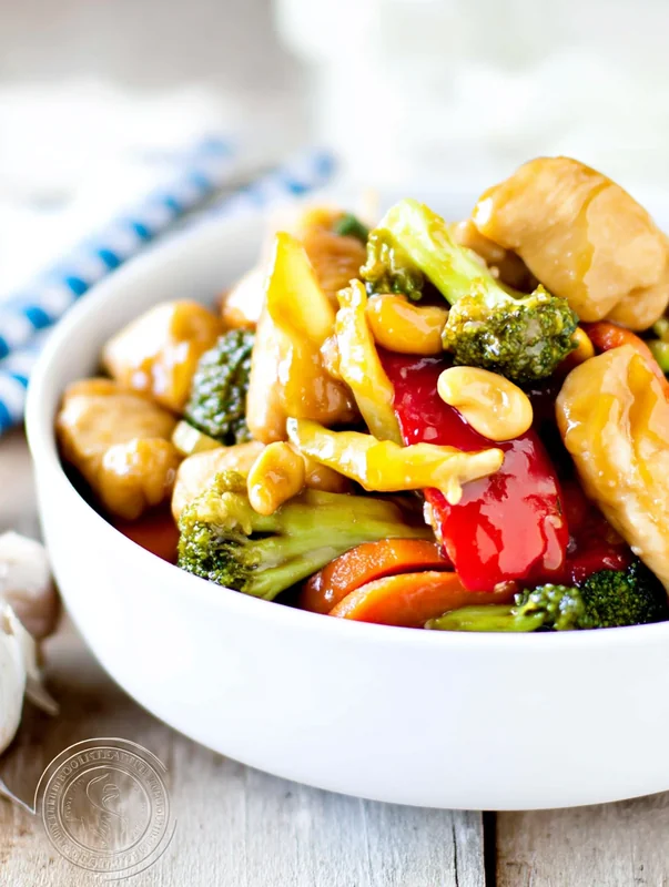 honey lemon chicken stir fry with red bell peppers and asparagus in a wok (honey lemon chicken stir fry homemade)