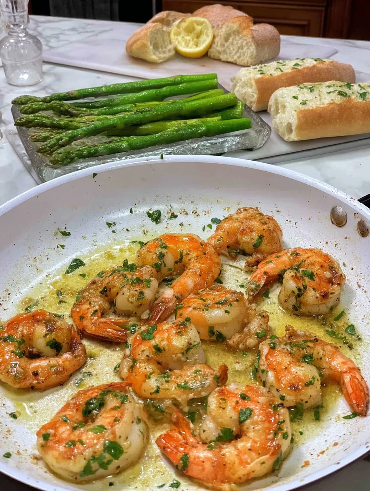 Lemon garlic butter shrimp recipe ingredients arranged on a cutting board with fresh asparagus